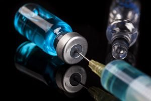 Needle and injection in bottle on the glass